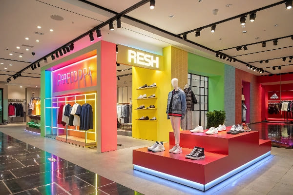 Colorida tienda de moda moderna con iluminación vibrante y pantallas de zapatos.