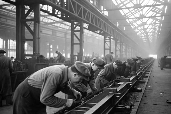Historisches Schwarzweißbild von Arbeitern in einer alten Industriefabrik