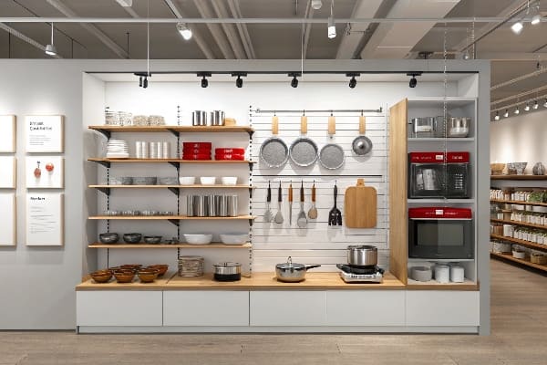 Pantalla minorista montada en la pared con productos de cocina y utensilios de cocina.