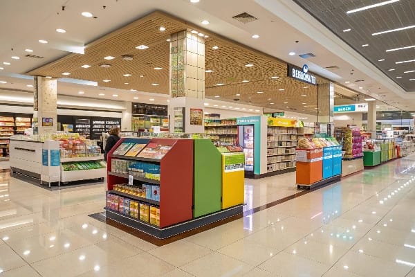 Intérieur spacieux de supermarché avec plusieurs unités d'affichage autoportantes et un éclairage vif.