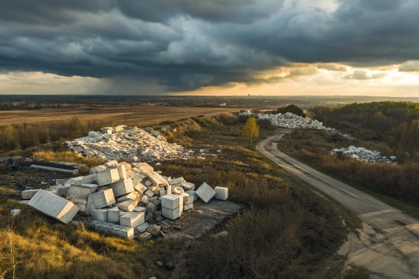 Large industrial waste piles of styrofoam blocks in rural landscape