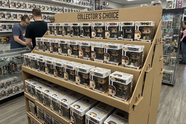 A large, multi-tiered cardboard display stand in a brightly lit collectible store, showcasing hundreds of Funko Pop! vinyl figures. The display is labeled