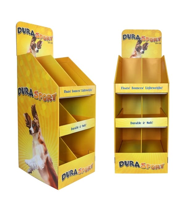 3 つの棚とペット用おもちゃのブランドが表示されている、黄色の波形フロアスタンドの斜めの視点。.