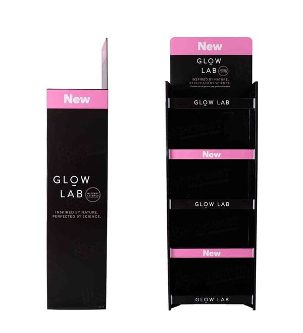 正面视角：一个空置的四层纸板落地展示架，设计用于展示化妆品和个人护理产品。.