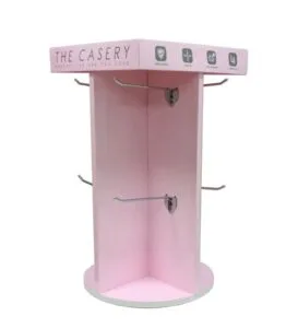A four-sided pink cardboard display with metal peg hooks for retail phone case merchandising.