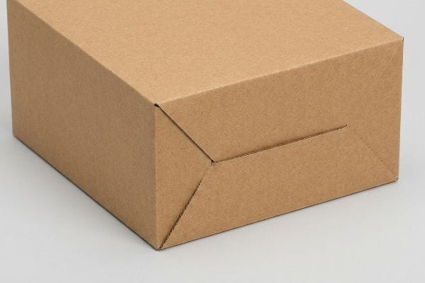 Brown corrugated cardboard box bottom showing precisely folded interlocking flaps and pre-scored crease lines for efficient assembly.