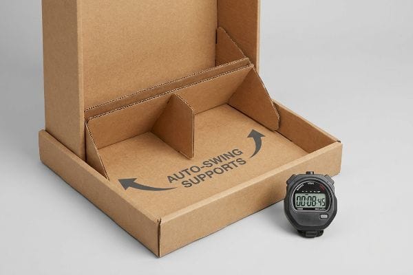 Corrugated cardboard display box with Auto-Swing Supports printed on the base, showing pre-glued internal supports and a black digital stopwatch displaying 00:08:45.