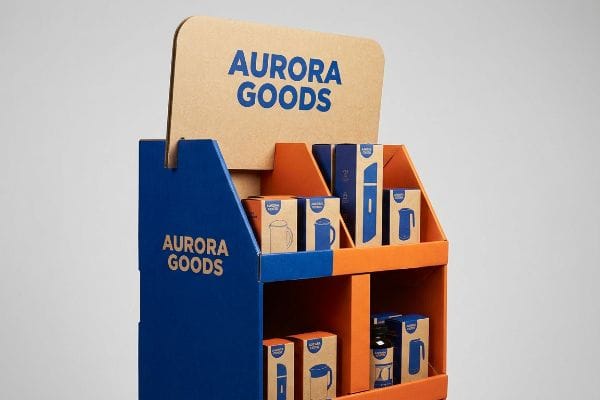 Vibrant blue and orange corrugated display for Aurora Goods, showcasing kraft boxes with product illustrations.