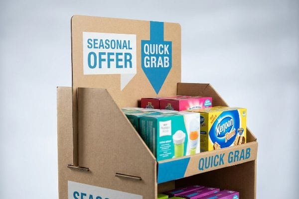 Corrugated cardboard POP display with 'Seasonal Offer' and 'Quick Grab' signs, blue arrow, and packaged products like Kenjoon Flakes.