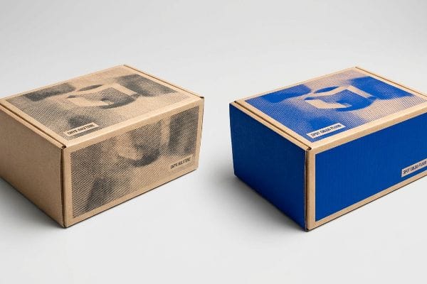 Natural brown kraft cardboard box with a black CMYK Halftone print, illustrating muddy halftone grain on porous paper fibers.