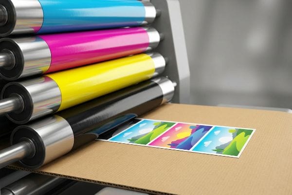 Una imprenta aplica tintas CMYK (cian, magenta, amarillo y negro) sobre cartón ondulado, creando gráficos llamativos para la venta al por menor.