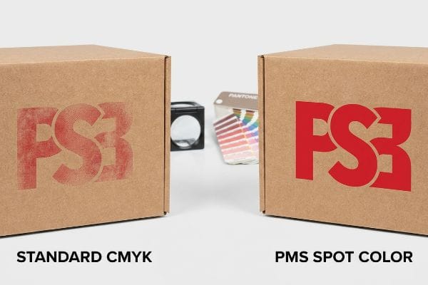 Two corrugated boxes compare faded red Ps3 Standard Cmyk printing to vibrant red Ps3 Pms Spot Color.