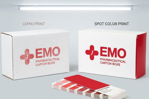 White pharmaceutical carton boxes demonstrate CMYK Print's faded Emo logo versus Spot Color Print's vibrant red Emo logo, with a Pantone swatch.