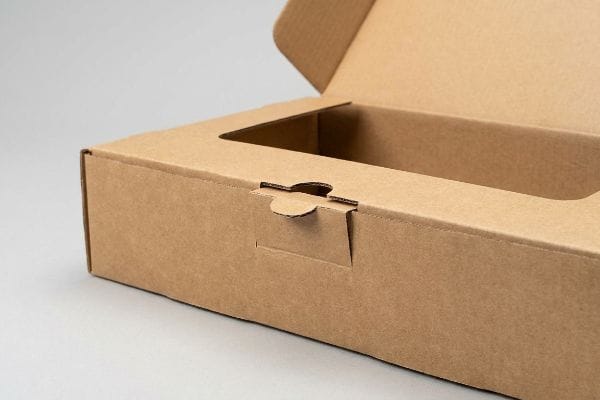 An open, empty brown corrugated die cut box features a precise tab closure and internal custom cut-out, showcasing sustainable kraft paper packaging.