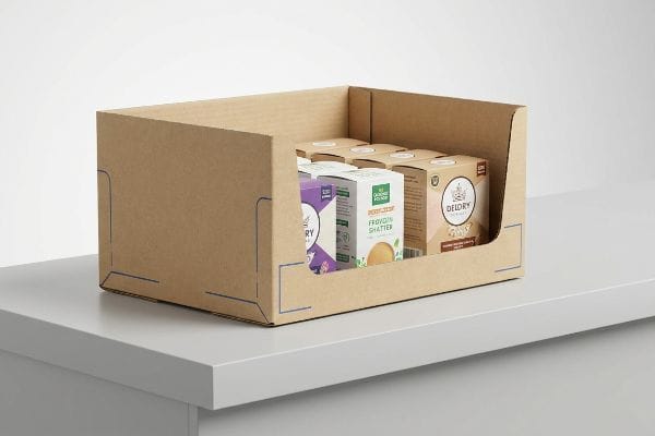 A corrugated cardboard PDQ display tray holds DelDry and All Goodness Foods Frovoin Shatter product boxes on a grey counter.