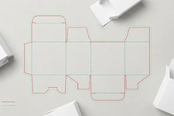 An overhead view displays a packaging dieline blueprint with red cut lines and blue dashed crease lines, alongside white box samples.