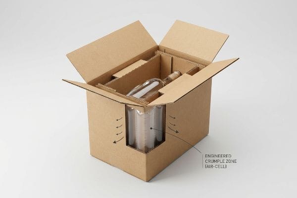 Cardboard shipping box with glass bottle, internal inserts, and Engineered Crumple Zone (Air-Cell) for impact.