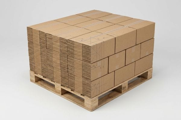 Brown corrugated cardboard sheets and assembled boxes stacked on a wooden pallet, illustrating efficient logistics array for freight density.