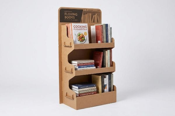 This sturdy three-tiered corrugated cardboard book display stand showcases 'Floving Books' branding and 'Cooking Fundamentals' on its top shelf, filled with diverse publications for retail.