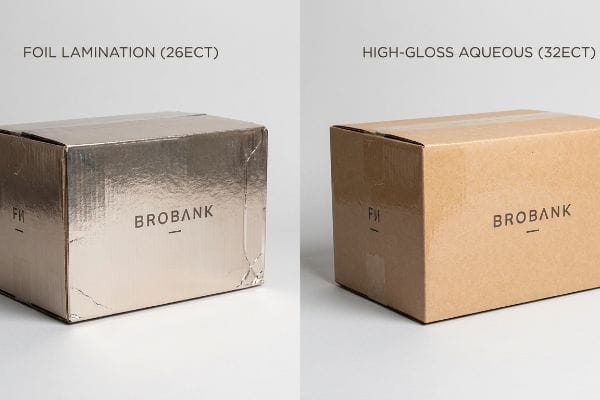 A Brobank box with shiny Foil Lamination (26ECT) next to a brown box with High-Gloss Aqueous (32ECT) finish.