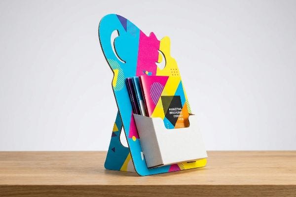 Vibrant custom die-cut cardboard brochure stand with geometric patterns, holding Marketing Brochure Download Here pamphlets.