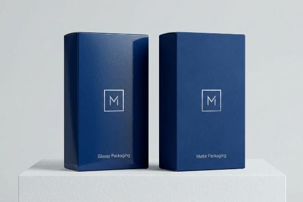 Two deep blue boxes, one Glossy Packaging and one Matte Packaging, both with a silver M logo, showcasing different finishes.