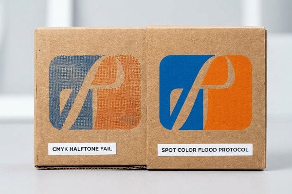 Brown corrugated boxes comparing print quality: CMYK Halftone Fail shows grainy blue and orange logo, while Spot Color Flood Protocol displays vibrant, solid blue and orange.