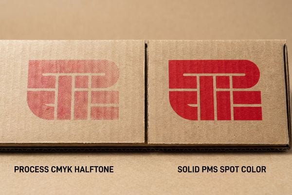 Two corrugated cardboard sections compare printing: a grainy Process Cmyk Halftone red logo versus a razor-sharp Solid Pms Spot Color red logo.