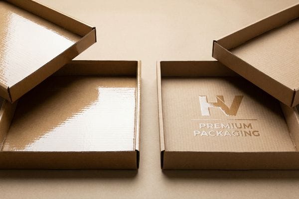 Corrugated cardboard boxes showcasing glossy UV coating and embossed HV Premium Packaging logo.