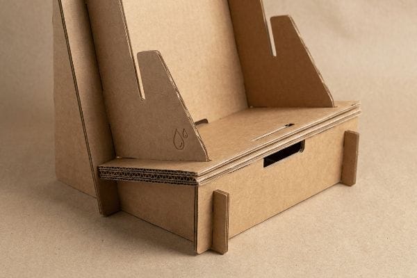 Brown corrugated kraft paper display with interlocking slots and a droplet symbol, showcasing moisture-resistant structural engineering.
