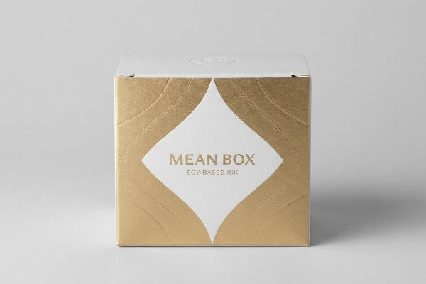 Gold foil and white square box for Mean Box Soy-Based Ink, highlighting sustainable premium packaging.