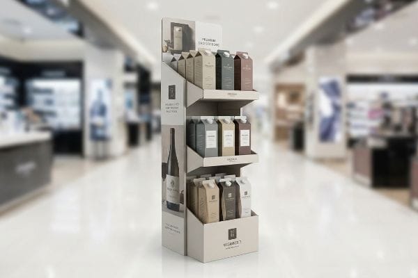 A multi-tiered cardboard display stand for Megaberry Premium Chocolate cartons, featuring a wine bottle graphic and 'Rich & Smooth' text, enhances visual merchandising in a retail store.
