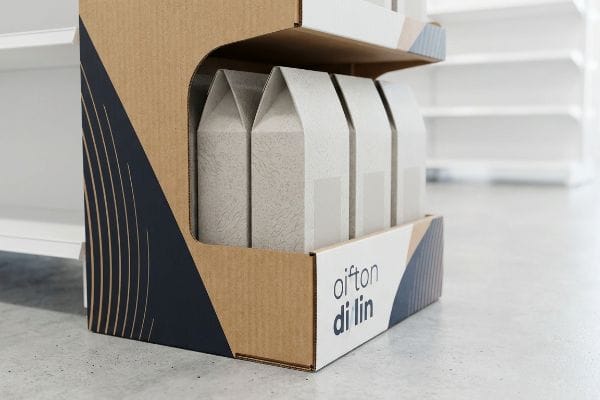Primer plano de un expositor POP de cartón ondulado 'oifton di lin' que contiene cajas de productos con forma de casa en la zona de venta al público.