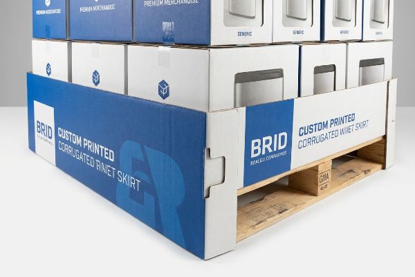Blue custom printed corrugated pallet skirt by BRID Braley Companies, featuring auto-locking tabs on a GMA wooden pallet.