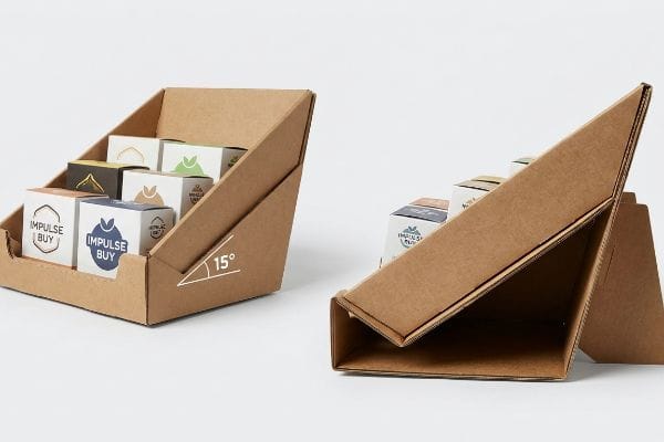 Brown corrugated cardboard PDQ display trays, one holding 'Impulse Buy' boxes, featuring a 15-degree product angle.