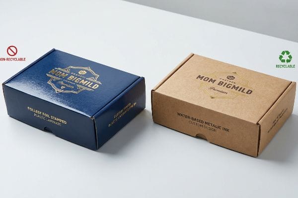 Dark blue Mom Bigmild carton with Pollesy Foil Stamped Plastic Laminate, next to a recyclable kraft box with Water-Based Metallic Ink.
