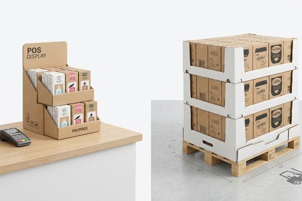 POS-Display aus Wellpappe von Prupdex auf einem Tresen, im Kontrast zu einem GMA-Palette-Display aus braunen Kartons.