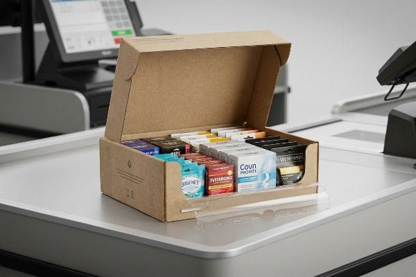 Natural brown corrugated retail-ready PDQ display tray filled with Covn Priority, Svedrondo, Juulnet, and Hryrewer products on a checkout counter.