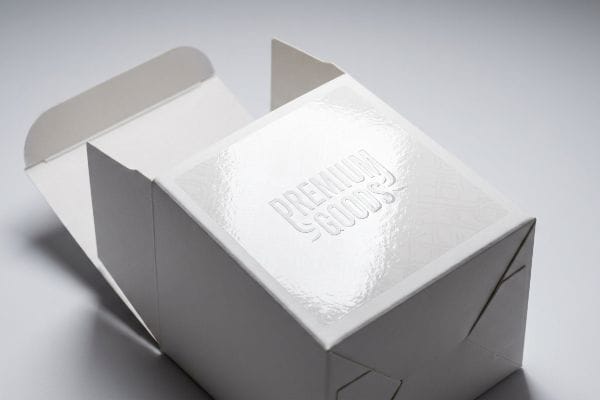An open white retail packaging box featuring a glossy UV coating and embossed