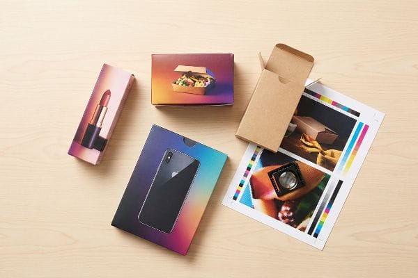 Retail product packaging for lipstick, smartphone, and takeout food, displayed with a print proof sheet showing CMYK color bars and halftone dots, highlighting continuous-tone photography and color gradients.