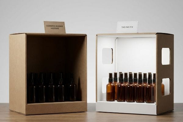 Raw kraft box, 'Common Rookie Mistake', obscures bottles. White-lined 'The Pro Fix' box clearly displays amber spray bottles.