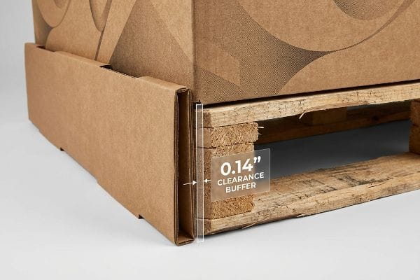 Faldón de cartón corrugado para palets que muestra un espacio libre de 0,14 pulgadas contra un palet de madera rugosa, lo que evita la fricción y los desgarros.