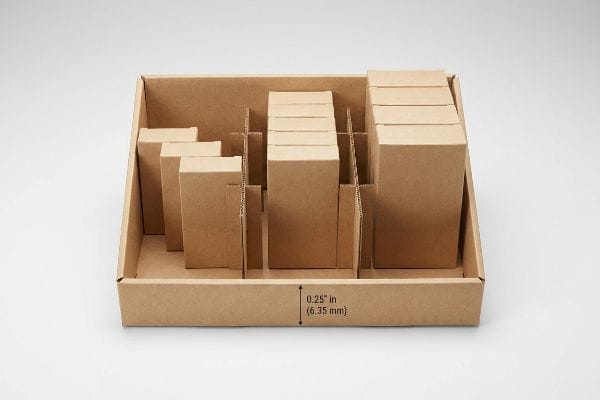 Bandeja expositora de cartón kraft marrón para venta al por menor, con separadores modulares entrelazados que permiten mostrar agrupaciones de productos asimétricas y un espacio libre de 0,25 pulgadas (6,35 mm).