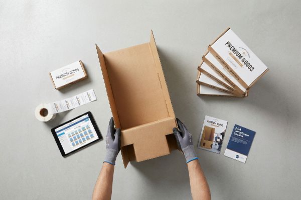 Gloved hands assemble a corrugated box, with