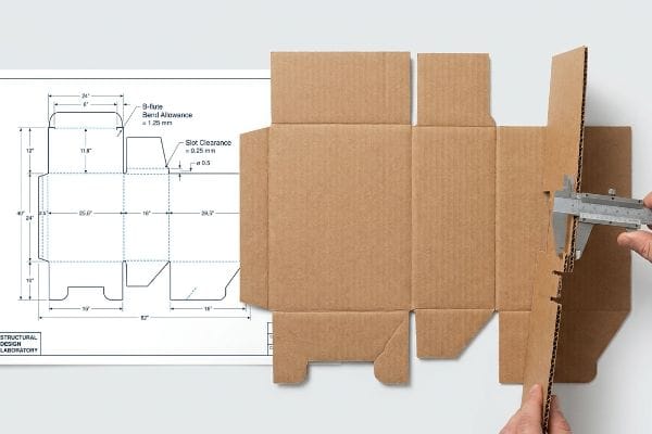Corrugated B-flute cardboard dieline, caliper measuring thickness, showing 'Bend Allowance = 1.25 mm' and 'Slot Clearance = 0.25 mm'.