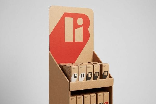 Natural kraft cardboard POP display featuring a red 'Bi' logo header and product boxes with black and white 'Bi' branding.