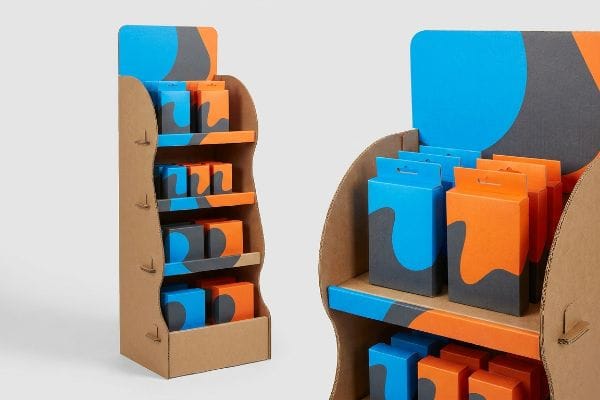 Corrugated cardboard POP display with blue and orange product boxes featuring a dark grey wavy design, optimized for retail.