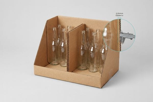 Brown corrugated display box with glass bottles, featuring a caliper measuring 0.25-inch clearance.