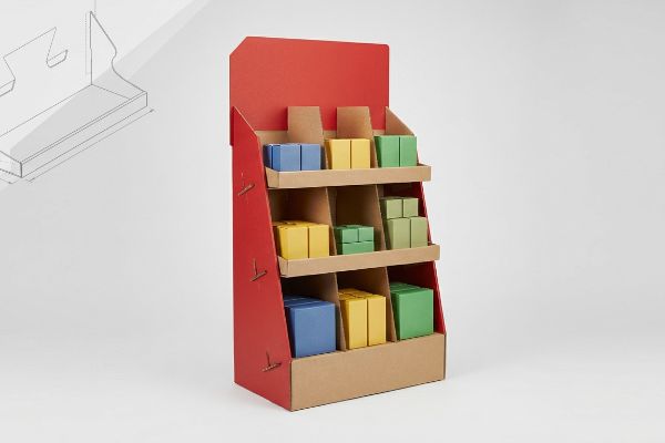 Red cardboard display stand with kraft modular shelves, holding colorful blue, yellow, and green product boxes.
