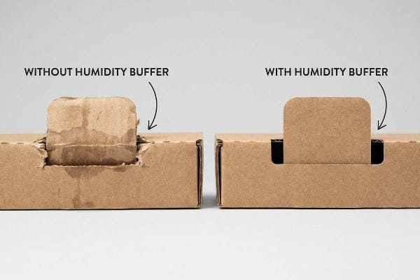 Brown corrugated cardboard boxes illustrating the difference: a torn, moisture-damaged tab Without Humidity Buffer versus an intact tab With Humidity Buffer.